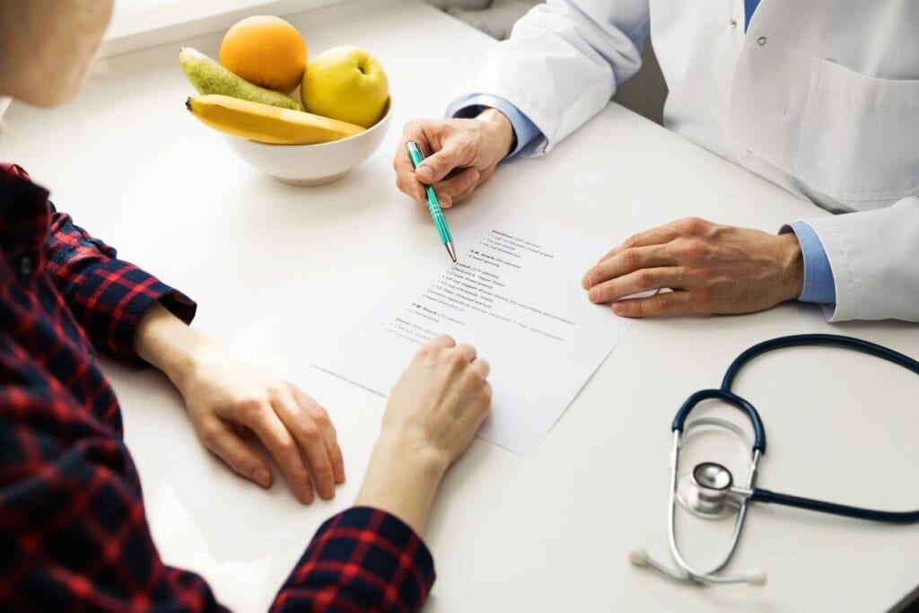 A doctor and two other people sitting at a table.